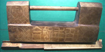 Large box-shaped lock of bronze with etched text; backsides are shown. Note the coin designs.