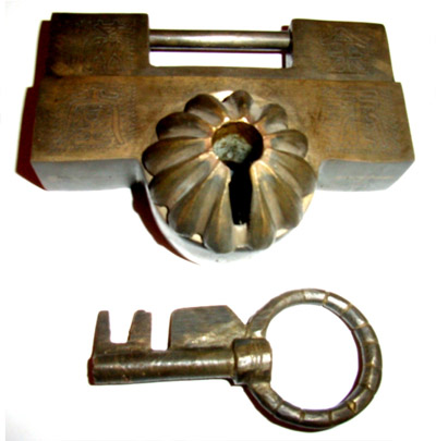 Box-shaped padlock of cast bronze with turning key. Photo by the author.